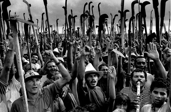 Trabalhadores Sem Terra empunhando bandeiras